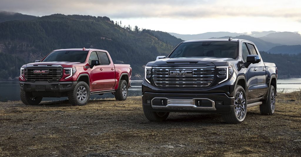 Two GMC Sierra 1500 trucks parked in a scenic outdoor setting