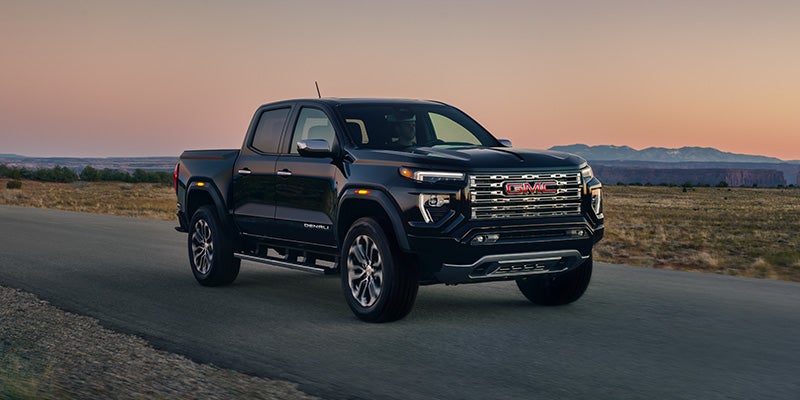 2026 GMC Canyon pickup truck driving on a scenic road